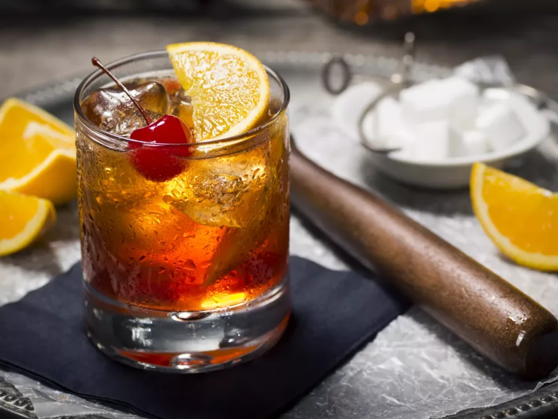 "The Old Fashioned is most commonly made by muddling sugar cubes with bitters, a cherry and an orange wedge or peel. Usually a splash of water or soda water is added along with ice, bourbon (or rye) and a garnish."